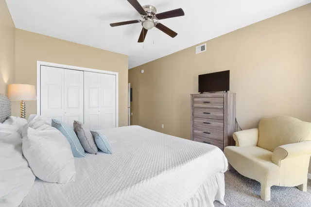 a bedroom with a bed a couch and a flat screen tv