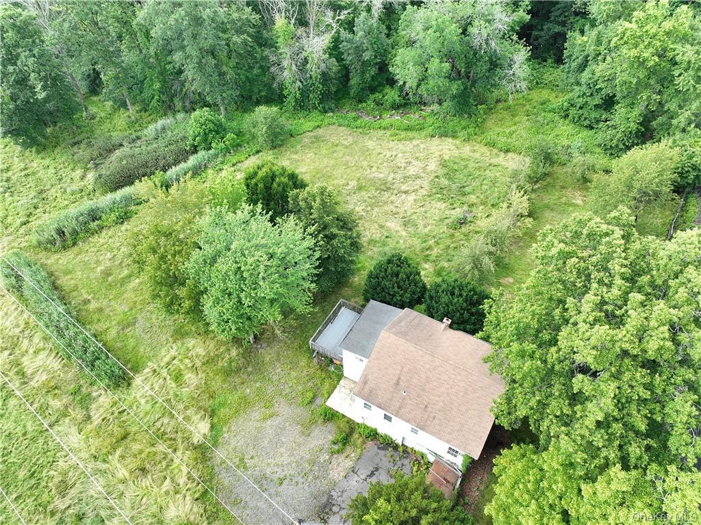 an aerial view of residential house with outdoor space and trees all around