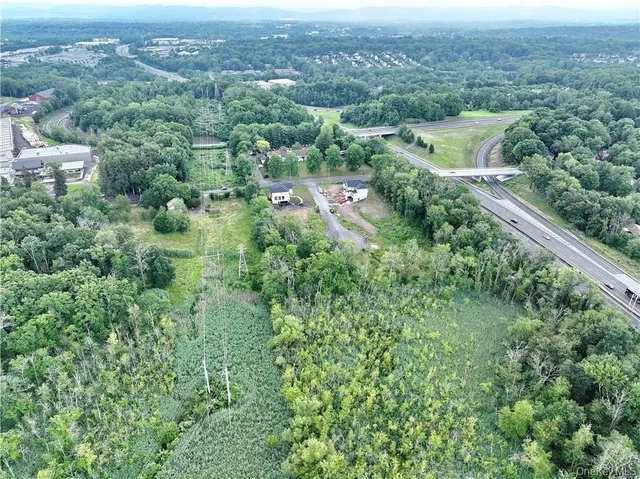 an aerial view of residential houses with outdoor space and trees