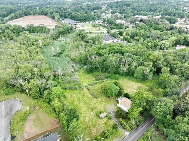 an aerial view of residential house with outdoor space and trees all around