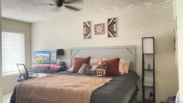 a large bed sitting in a bedroom next to a window and a lamp