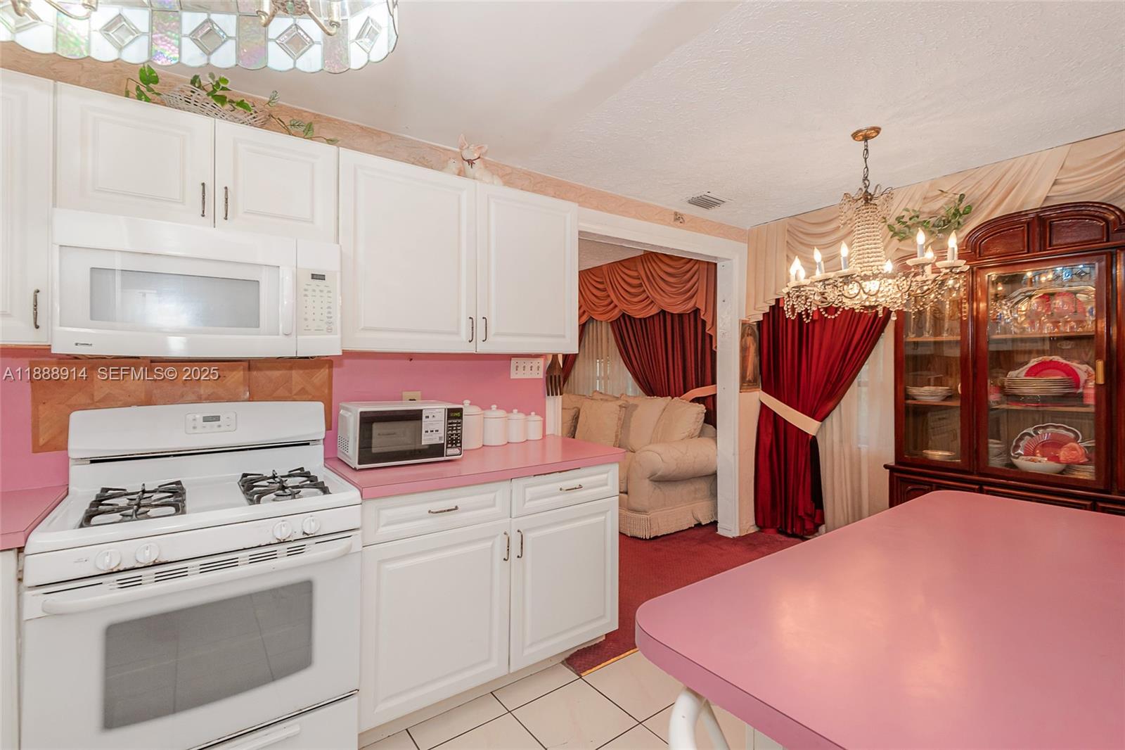 1083 Northwest 74th Street Miami, FL 33150 - Photo 13 of 28 a kitchen that has a lot of white cabinets and white appliances