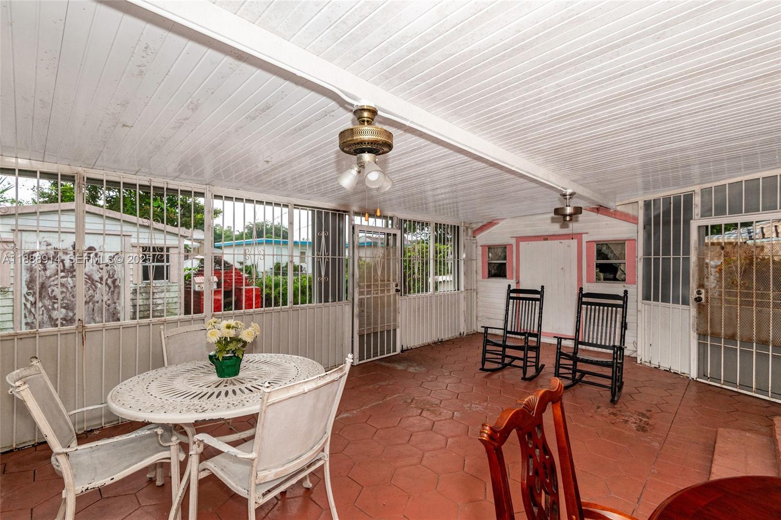 1083 Northwest 74th Street Miami, FL 33150 - Photo 25 of 28 a dinning table and chairs in patio of a house