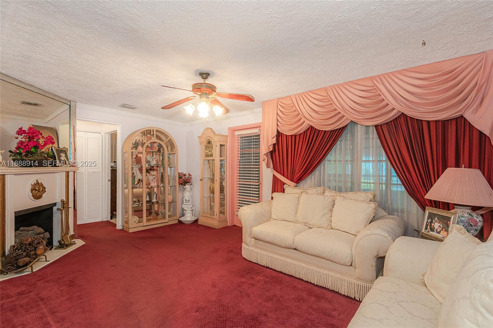 1083 Northwest 74th Street Miami, FL 33150 - Photo 6 of 28 a living room with furniture a flat screen tv and a fireplace