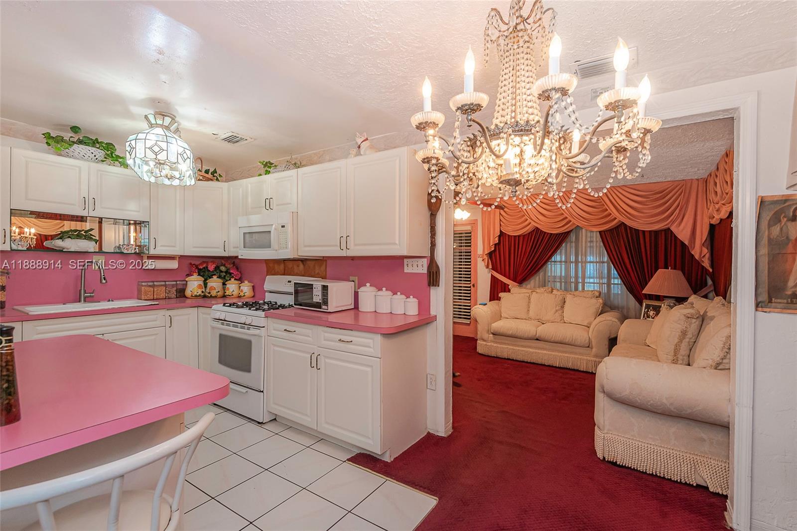 1083 Northwest 74th Street Miami, FL 33150 - Photo 9 of 28 a kitchen filled with a white cabinets and chandelier
