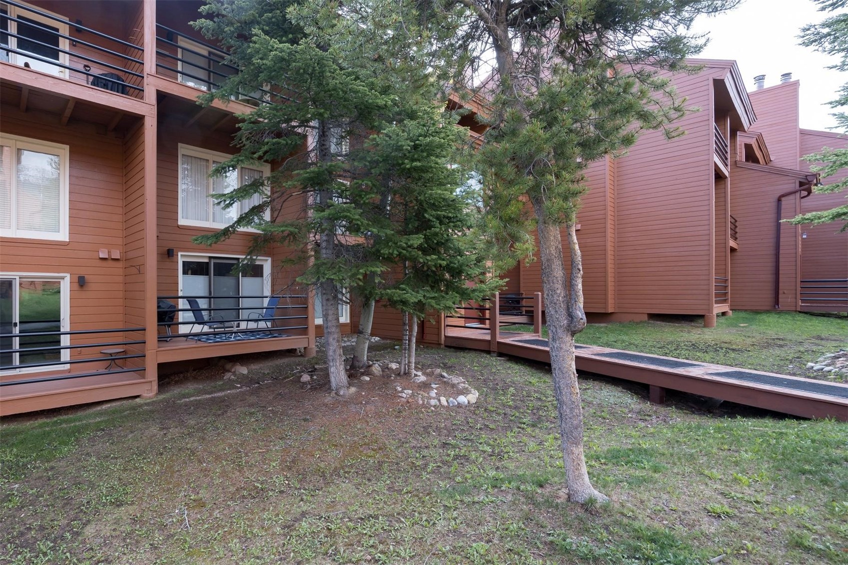 91100 Ryan Gulch Road, Unit 91105 Silverthorne, CO 80498 - Photo 26 of 49 a backyard of a house with barbeque oven and trees