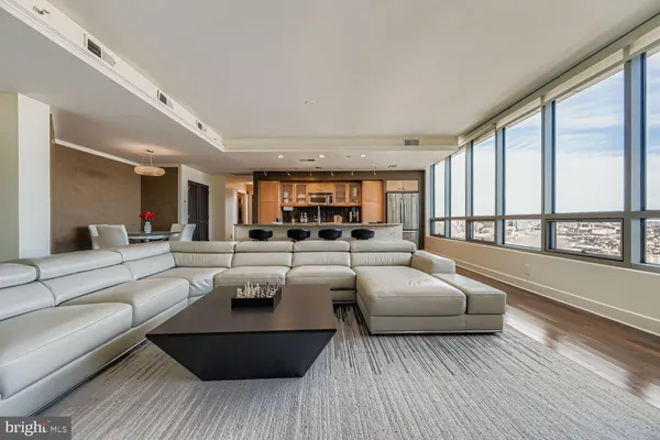 a living room with furniture and floor to ceiling windows