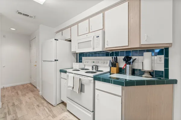 a kitchen with stainless steel appliances granite countertop a sink and a refrigerator