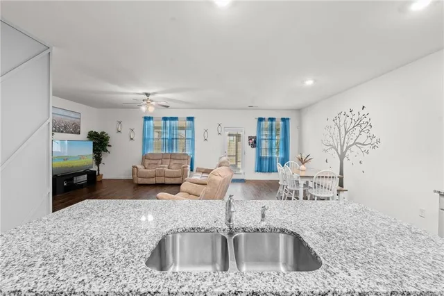 a kitchen with granite countertop a sink and a stove top oven