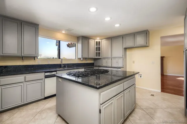 a kitchen with stainless steel appliances granite countertop a sink stove and cabinets
