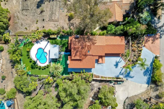 an aerial view of a house with a yard and swimming pool