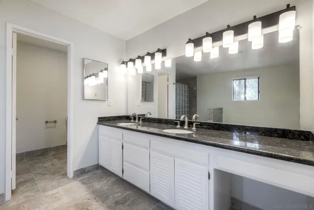 a large bathroom with a large mirror vanity and shower