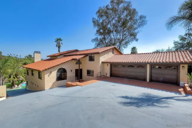 a white house with a large tree in front of it