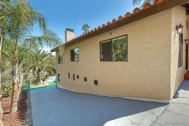 a view of a white house with a big yard and large trees