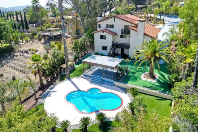 an aerial view of a house with a yard and large trees