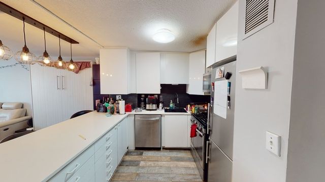 a view of a dining area with refrigerator and chandelier