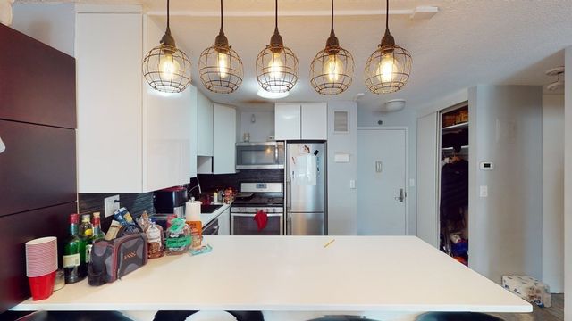 a kitchen view of kitchen island a sink and a stove