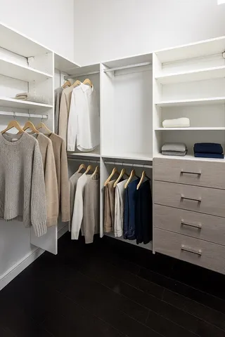 a view of walk in closet with clothes and shoes