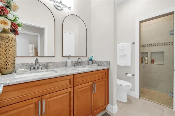 a bathroom with a granite countertop sink mirror and toilet