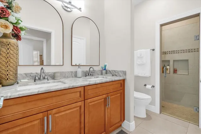 a bathroom with a granite countertop sink mirror and toilet