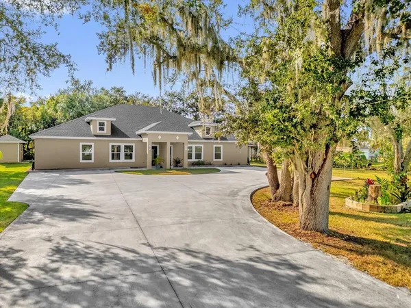 a front view of house with yard and trees around
