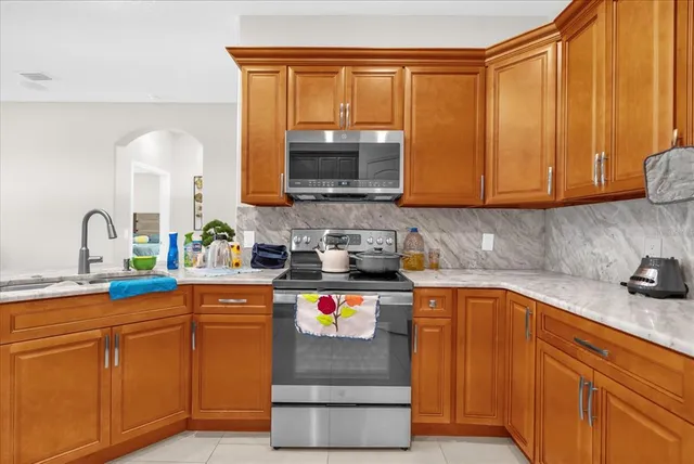 a kitchen with stainless steel appliances granite countertop a sink stove and cabinets