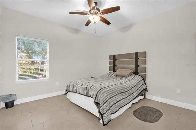 a bedroom with a bed chandelier and a window