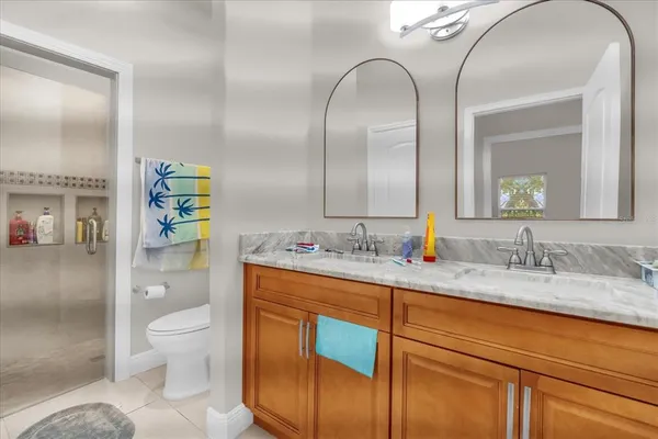 a en suite bathroom with a granite countertop toilet sink and mirror