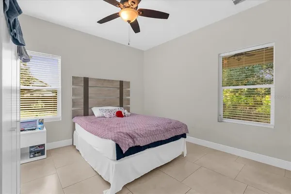 a spacious bedroom with a bed and a chandelier