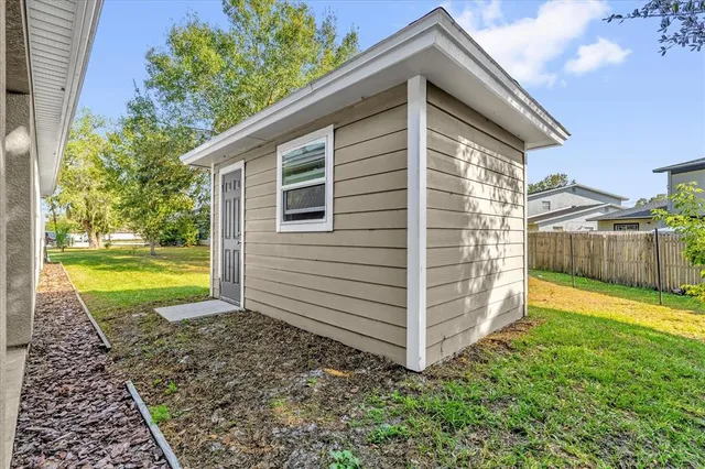 a view of a house with backyard and a tree