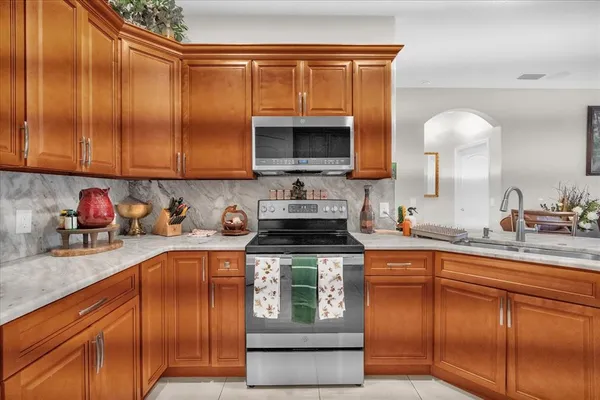 a kitchen with stainless steel appliances granite countertop a sink stove and cabinets