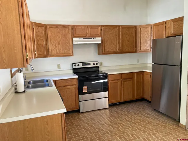 a kitchen with a stove a refrigerator and a sink