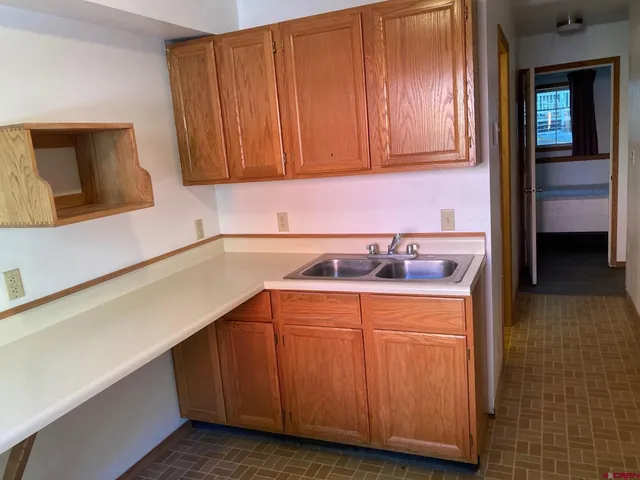 a kitchen with a sink cabinets and a wooden floor