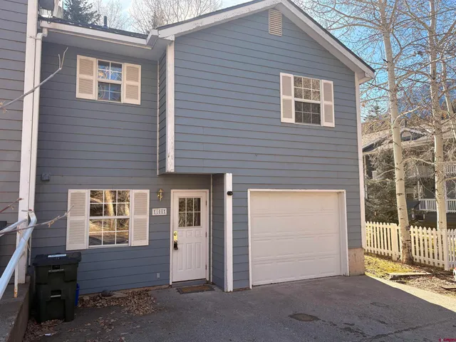 a front view of a house with a yard and parking space