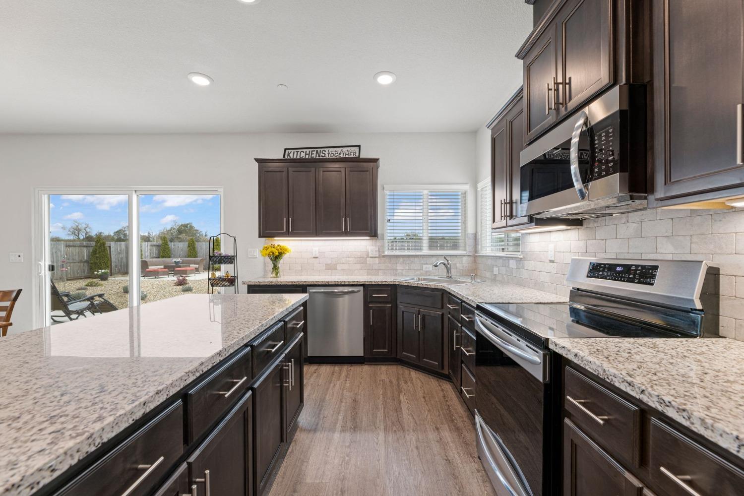 a kitchen with stainless steel appliances granite countertop sink stove microwave and cabinets