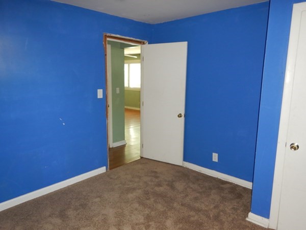 23 Vincent Street Springfield, MA 01129 - Photo 17 of 20 a view of an empty room with closet and wooden door