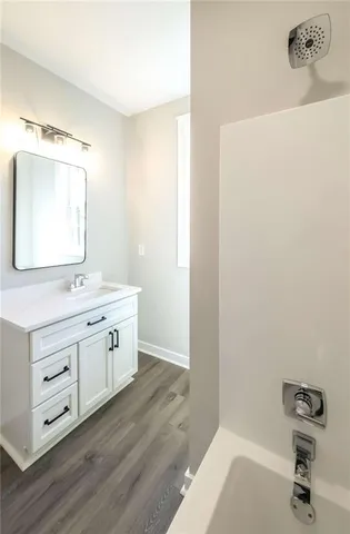 a bathroom with a tub sink and mirror