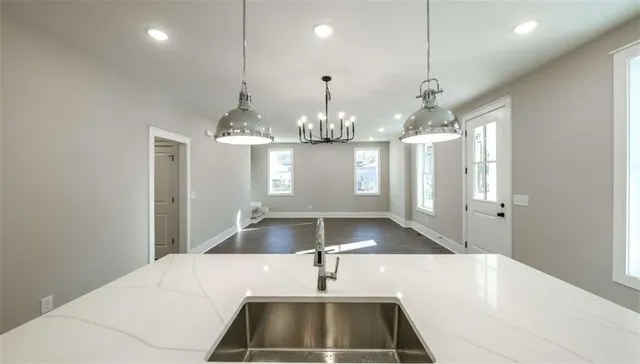 a room with kitchen island a sink and a chandelier