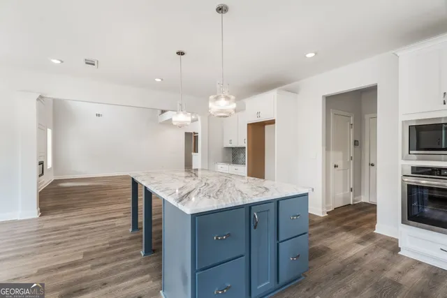 a bathroom with a toilet a sink and wooden floor