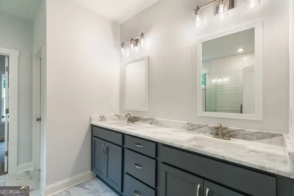 a spacious bathroom with a granite countertop sink mirror and shower