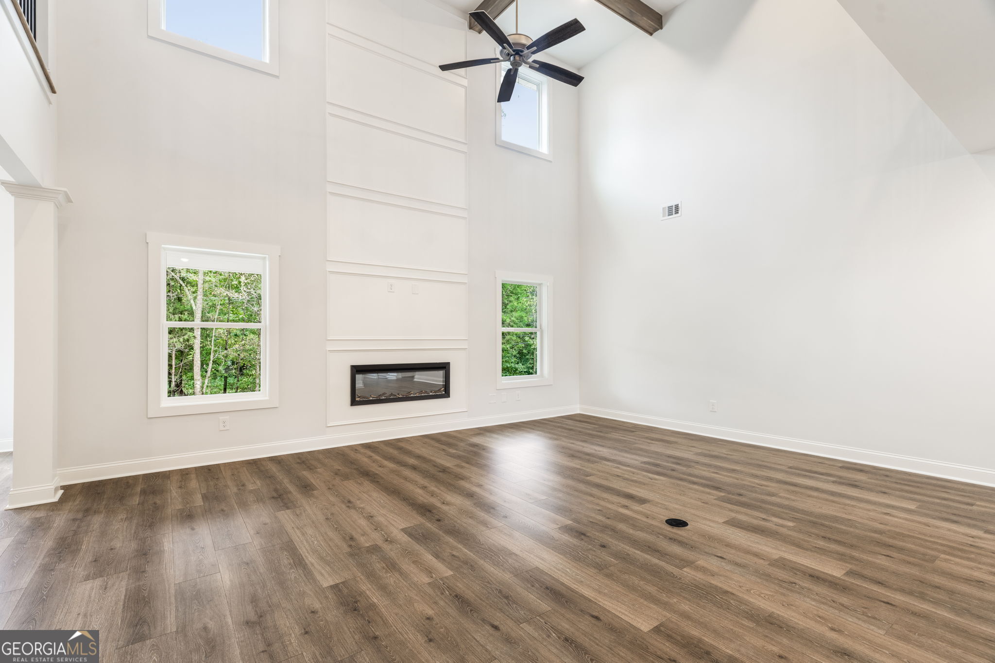 102 Mill Race Road Thomaston, GA 30286 - Photo 7 of 57 an empty room with wooden floor a fireplace and windows