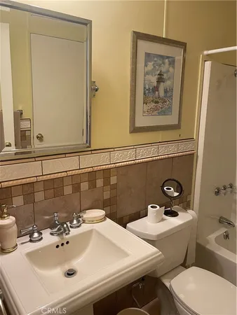 a bathroom with a sink mirror and toilet