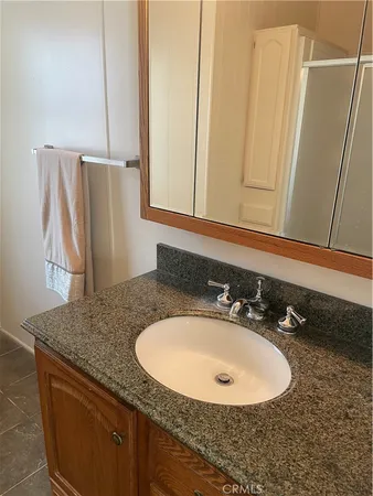 a bathroom with a granite countertop sink and a mirror