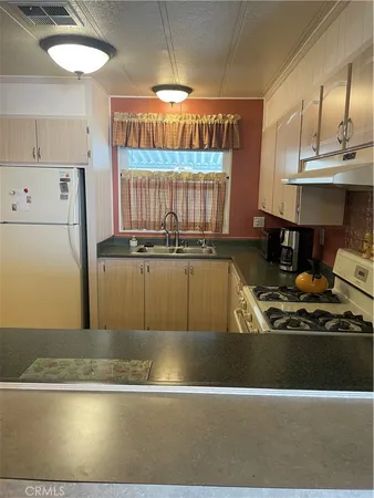 a kitchen with a sink a stove and a refrigerator