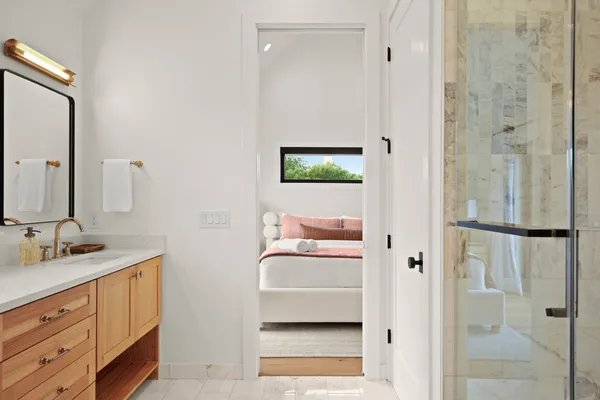 a en suite bathroom with a granite countertop sink and a mirror