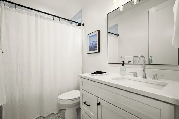 a bathroom with a sink a toilet and a mirror