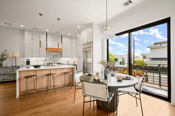 a kitchen with a table chairs stove and kitchen view