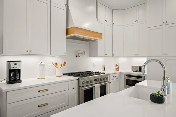 a kitchen with granite countertop a sink a stove and cabinets