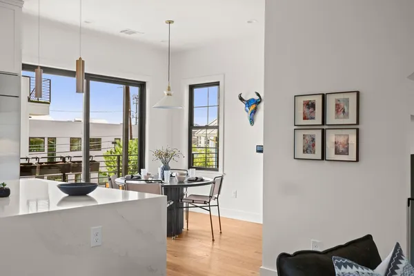 a living room with furniture large window and wooden floor