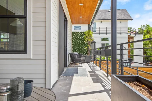 a balcony with chairs and with potted plants